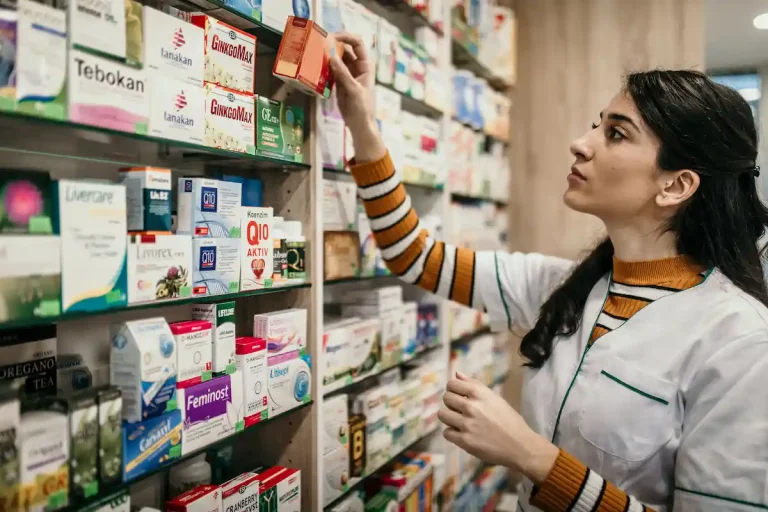 Farmacia en Malta con farmacéutica organizando medicamentos en los estantes