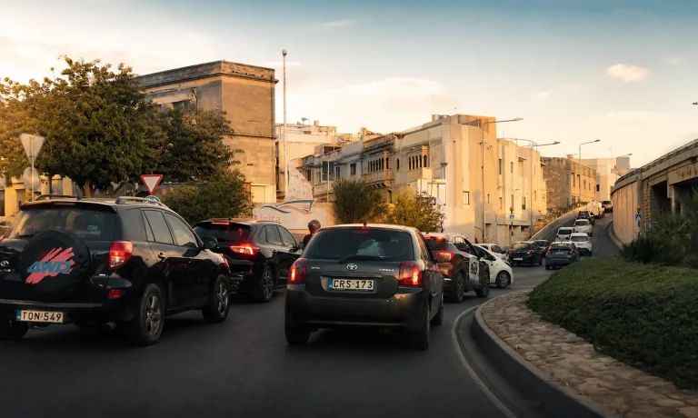Tráfico en una carretera de Malta durante la hora punta, con varios coches circulando por una intersección urbana.
