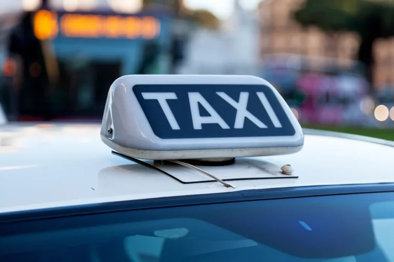Taxi con luz “TAXI” encendida en el techo circulando por una calle urbana en Malta