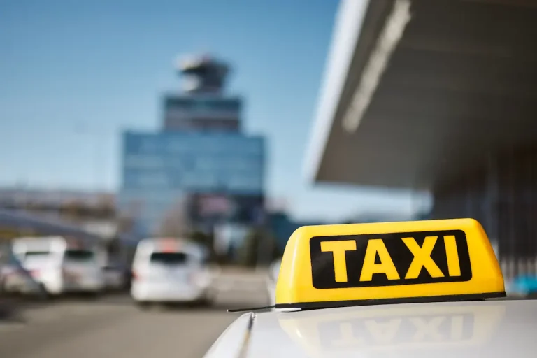 Taxi frente al aeropuerto de Malta con el cartel amarillo de “TAXI” en el techo.