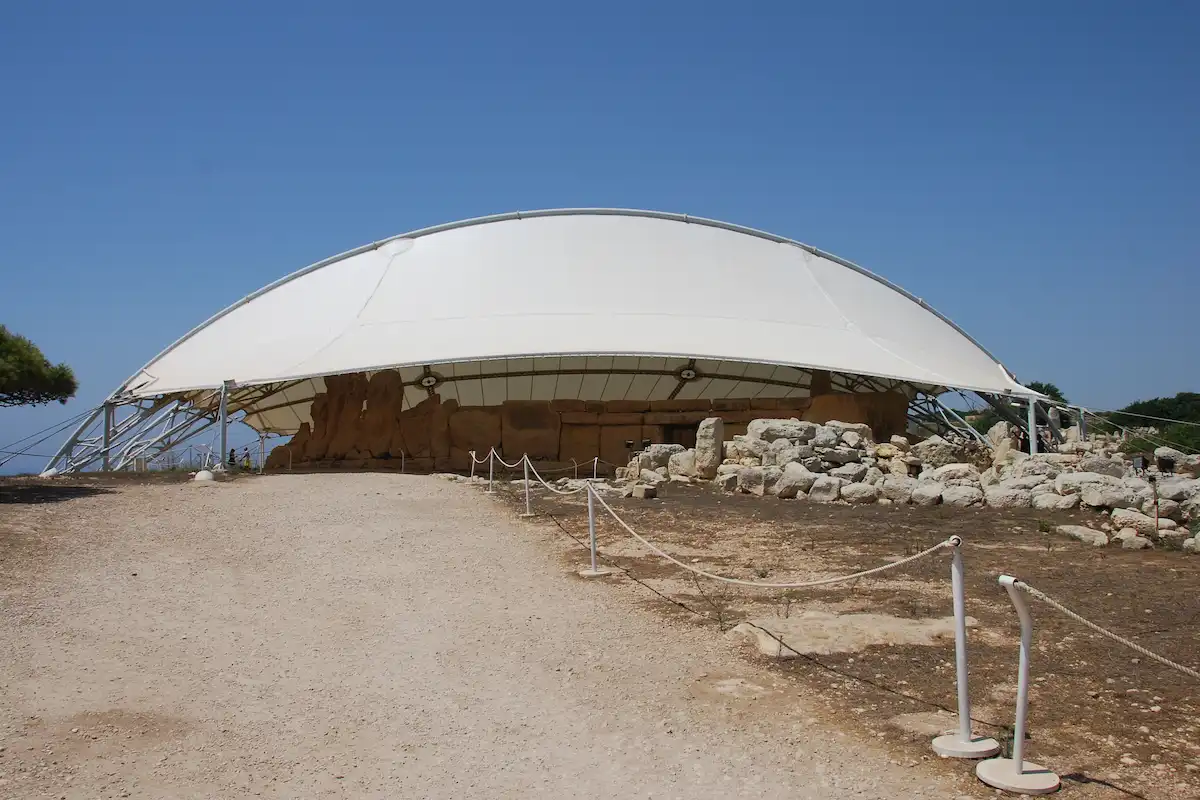 Cubierta protectora blanca sobre el templo megalítico de Ħaġar Qim en Malta en un día soleado.