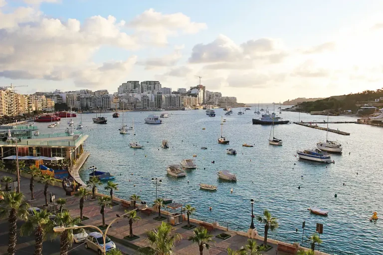 Vista del paseo marítimo de Sliema con el puerto, barcos anclados y edificios residenciales al fondo, uno de los principales destinos tras llegar a Malta.