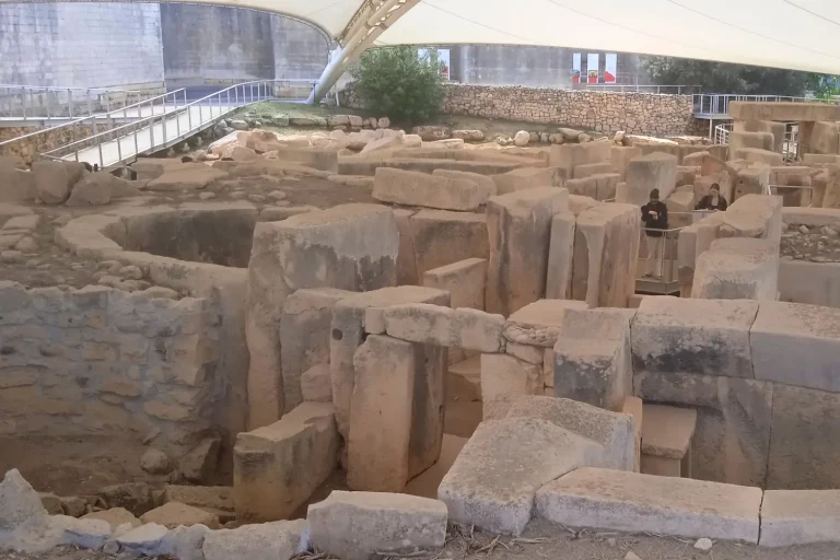 Templos de Tarxien en Malta: cámaras y portales megalíticos del complejo neolítico con visitantes que muestran la escala de las construcciones.