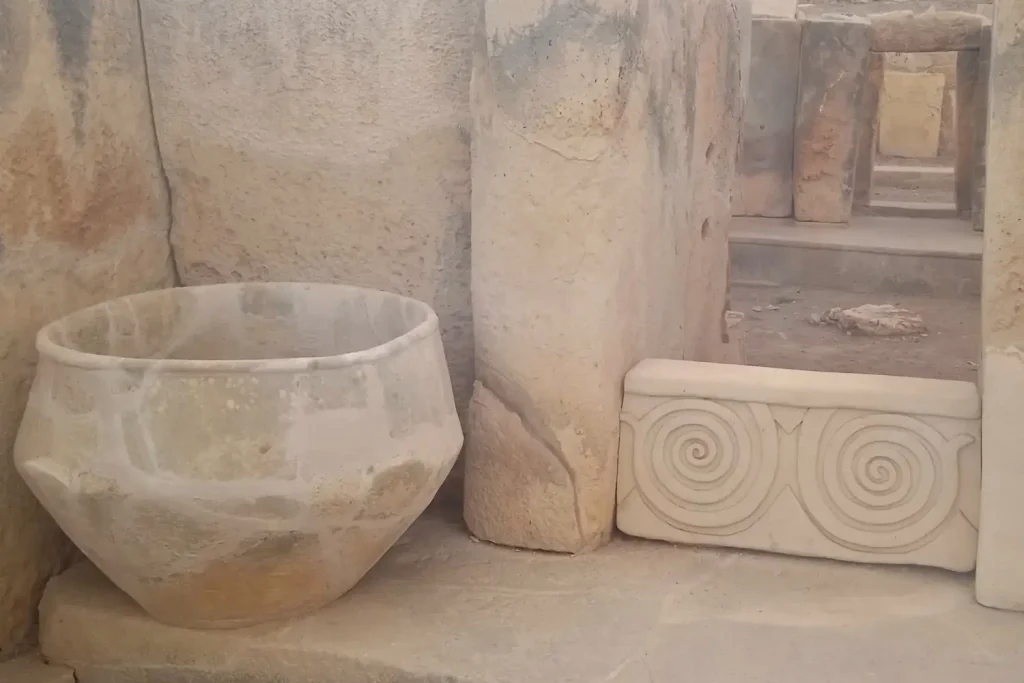 Cuenco ritual de piedra y ornamentos en espiral tallados en piedra caliza en el templo de Tarxien en Malta.