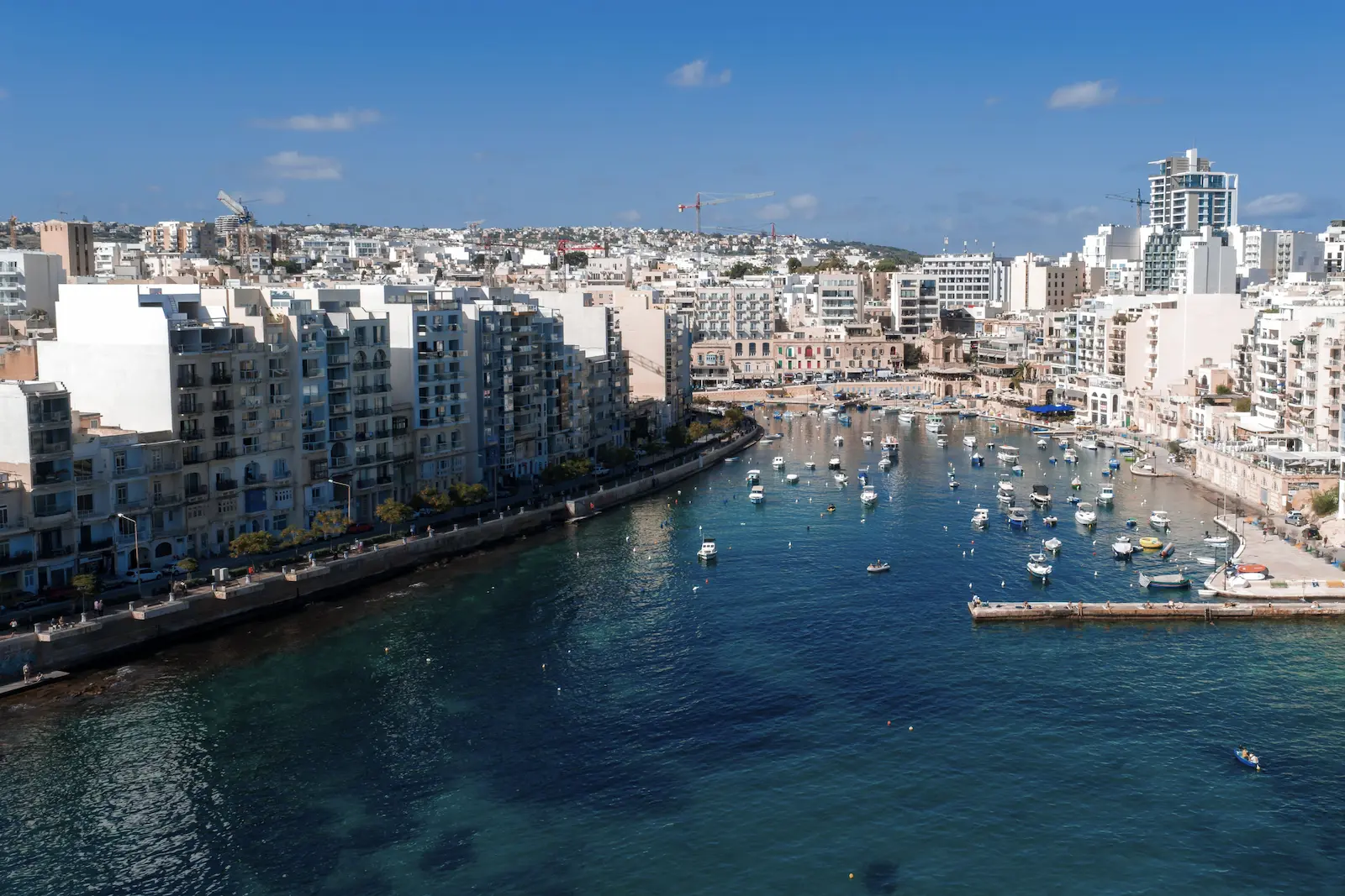 Vista panorámica de Spinola Bay con barcos y edificios urbanos en St. Julian’s, Malta